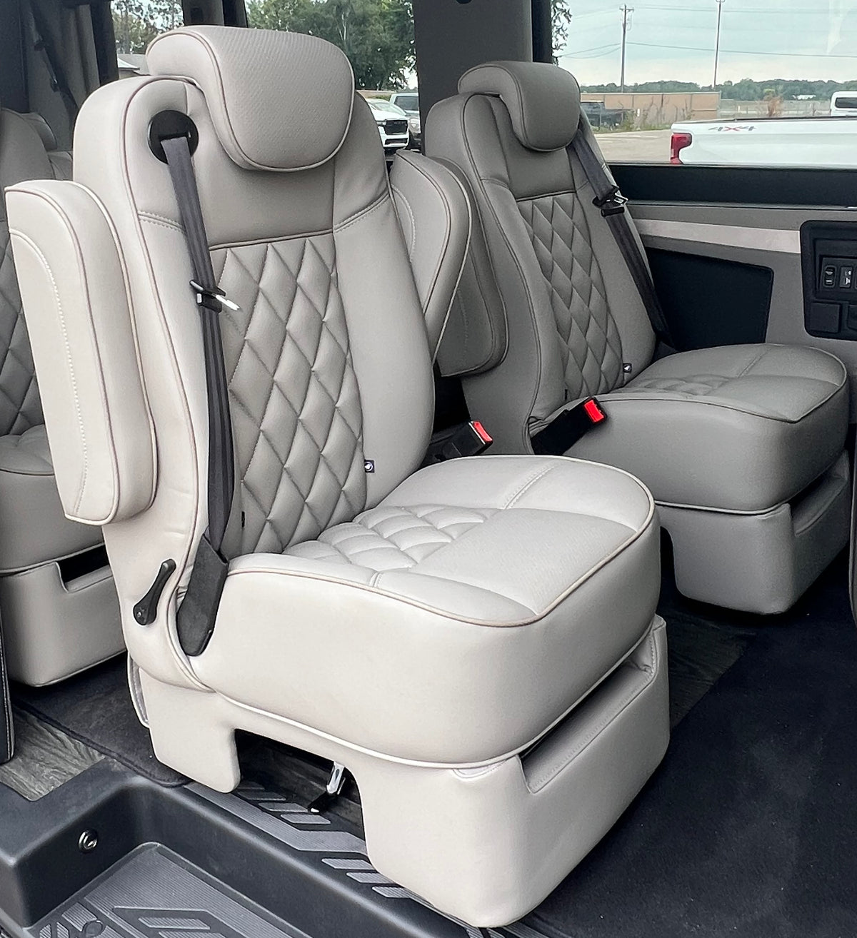 MIDDLE BUCKET SEAT - DS - DUAL ARM RESTS WITH HARD SKIRT COLOR: MEDIUM NEUTRAL W/ NEUTRAL PIPING W/ NEUTRAL PERF INSERTS